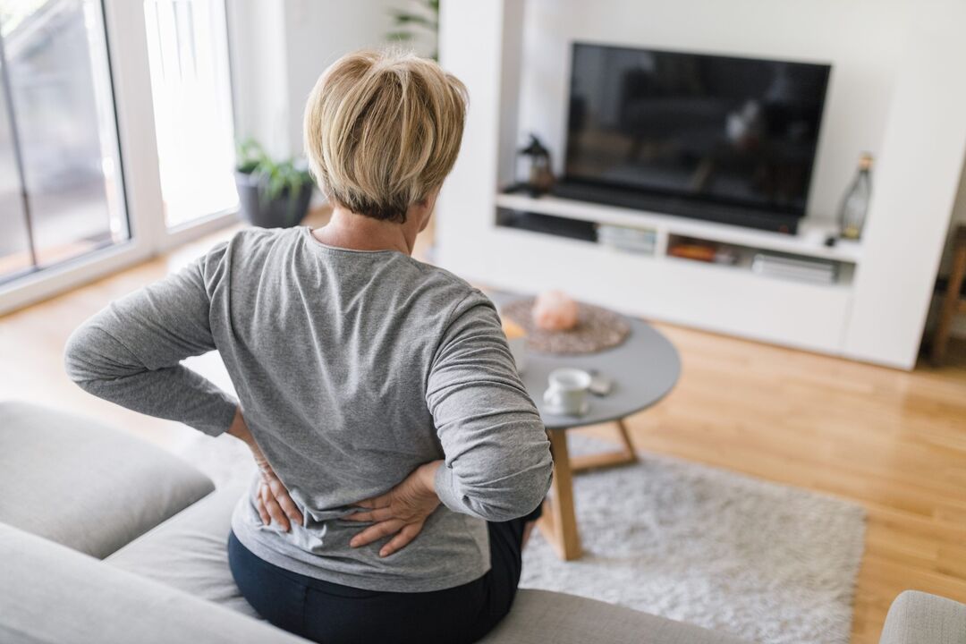 Una donna è preoccupata per il mal di schiena nella regione lombare